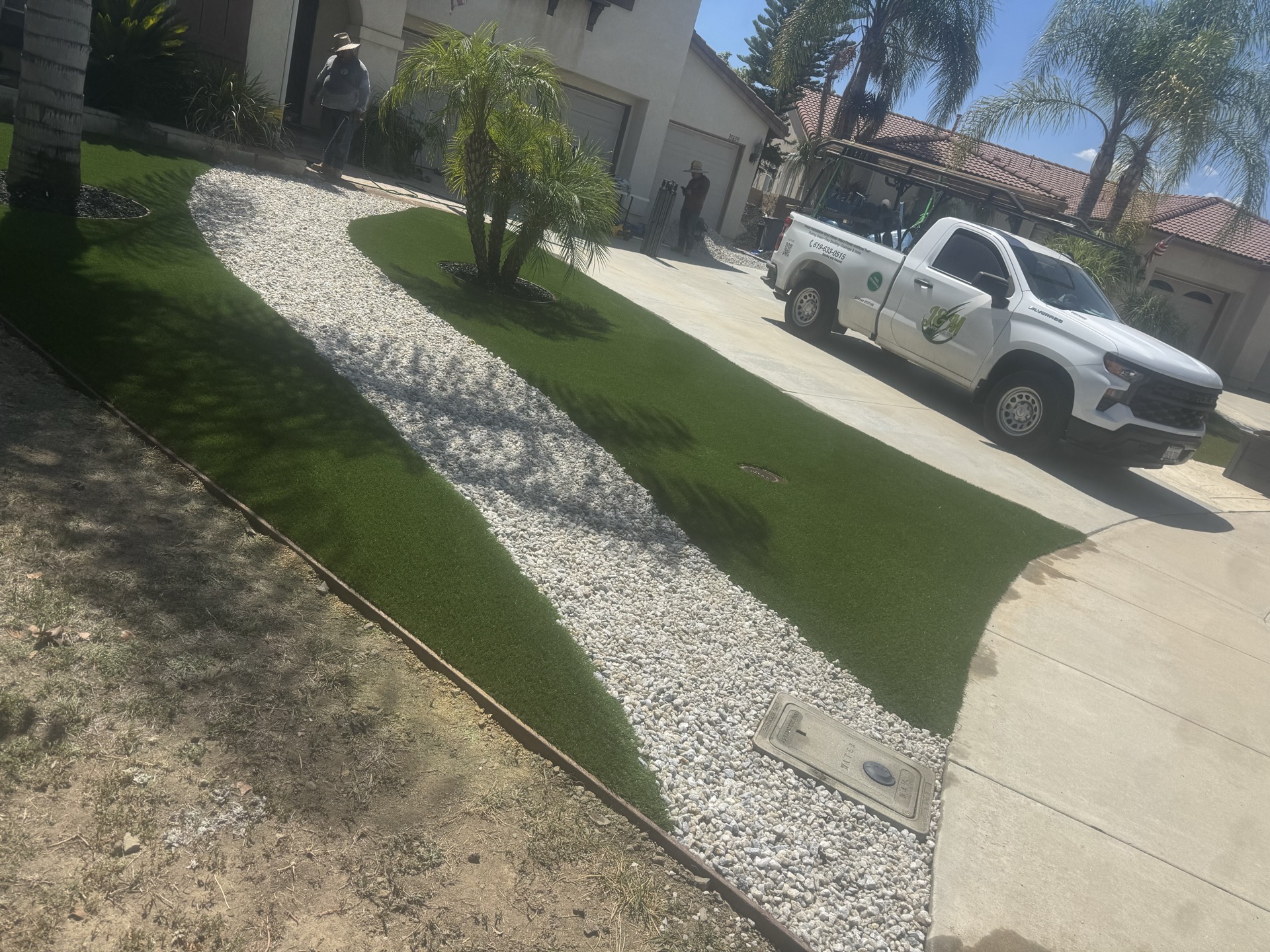 Front yard artificial turf with gravel borders and palm trees