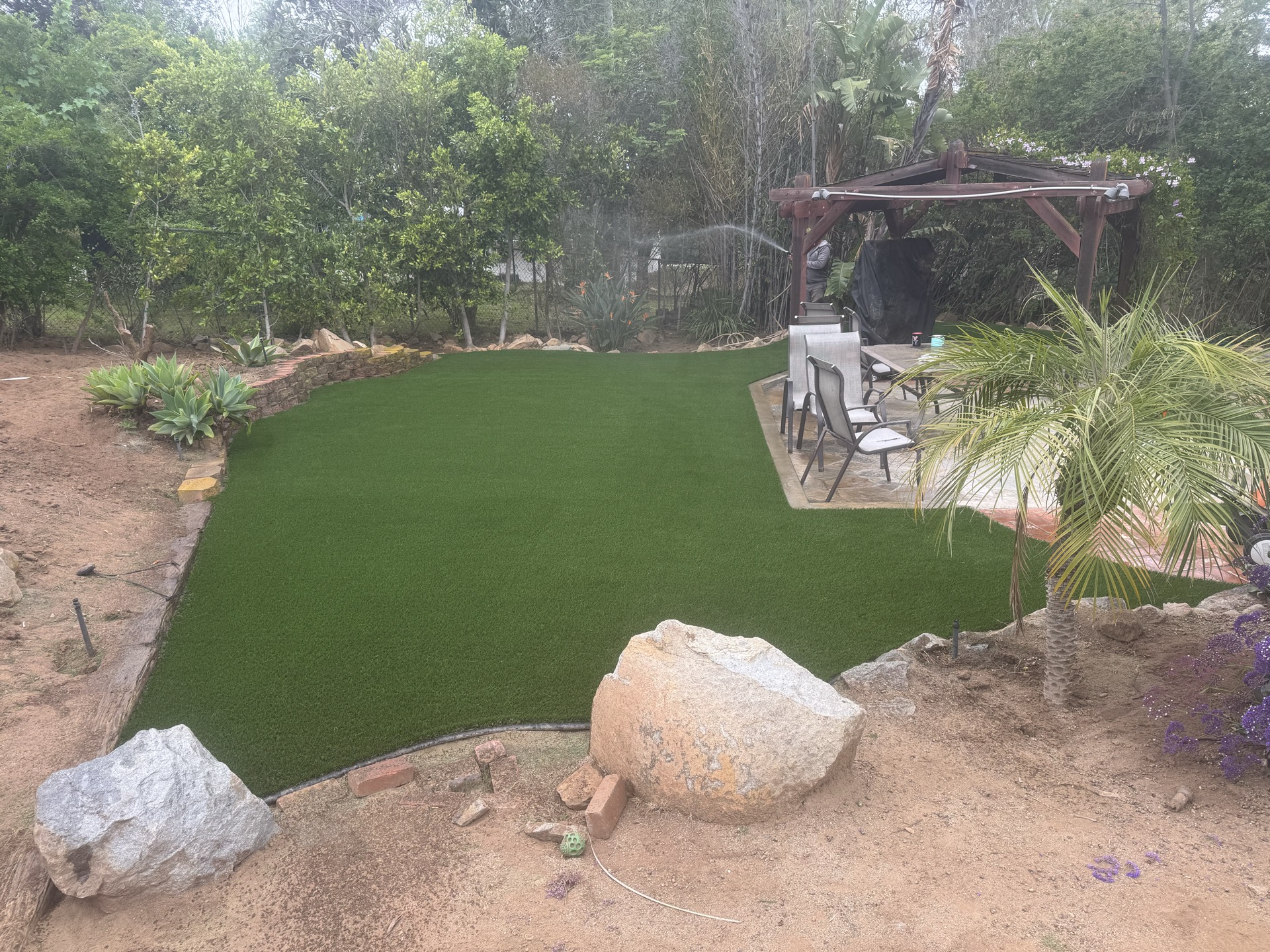 Landscape grading with boulder placement during installation in San Diego