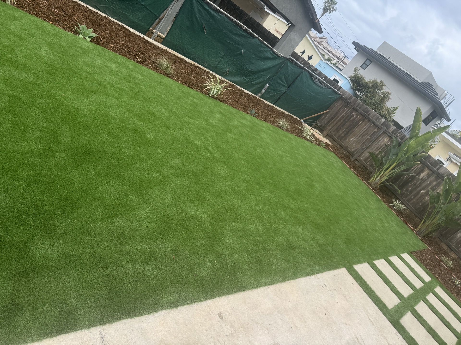 Landscape design with artificial turf and planting beds