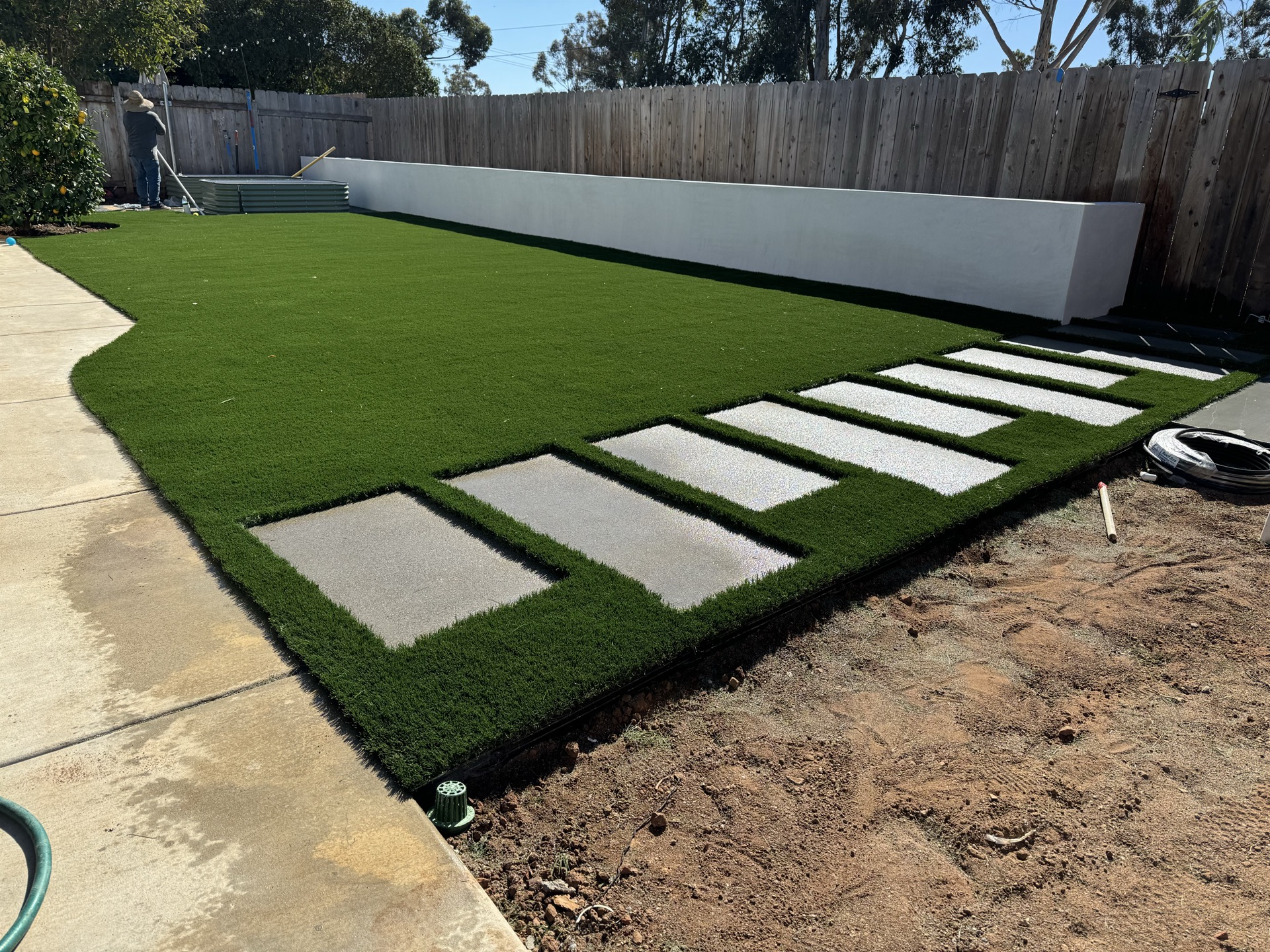 Concrete stepping stones in turf walkway during installation in San Diego